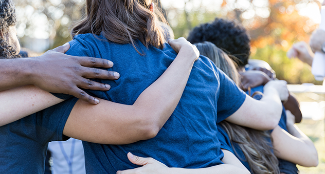 Group of diverse people hugging.