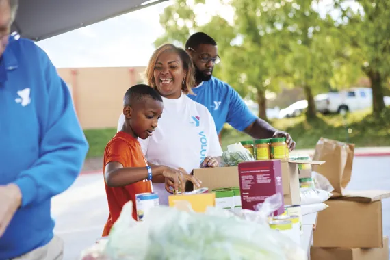Volunteer serving groceries at an event.