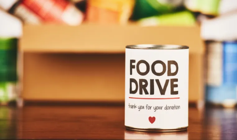 Food drive can with a box of cans in the back