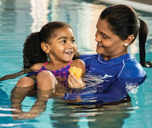 Swim instructor with child in pool