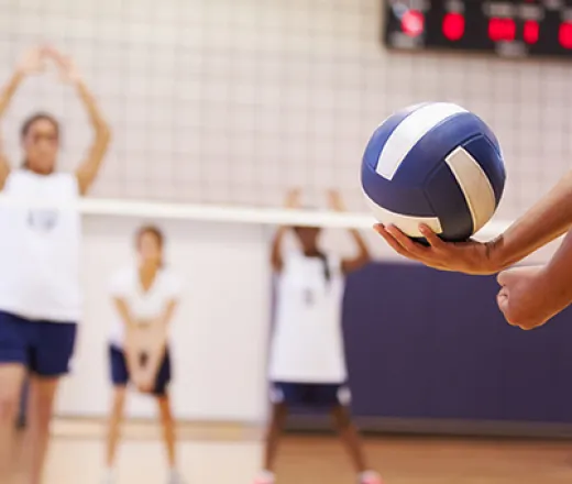 someone serving a blue volleyball