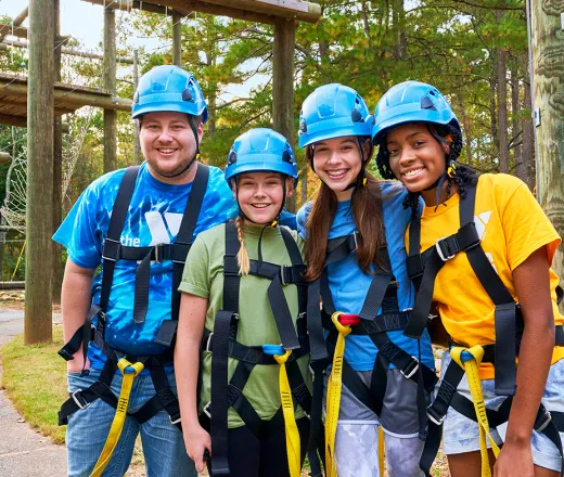 group of kids and a counselor doing a challenge course